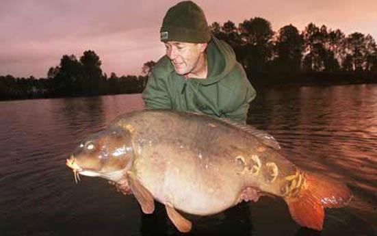 BNPS.co.uk (01202 558833) Picture: Collect Ice cool Martin Lock (47) braved sub zero temperatures in just a t-shirt to land the World's biggest carp fish. Brit Martin, from Kent, jumped out of his lakeside tent near Bordeaux, in France, at 6am to net the monster fish that weighed in at 94lbs